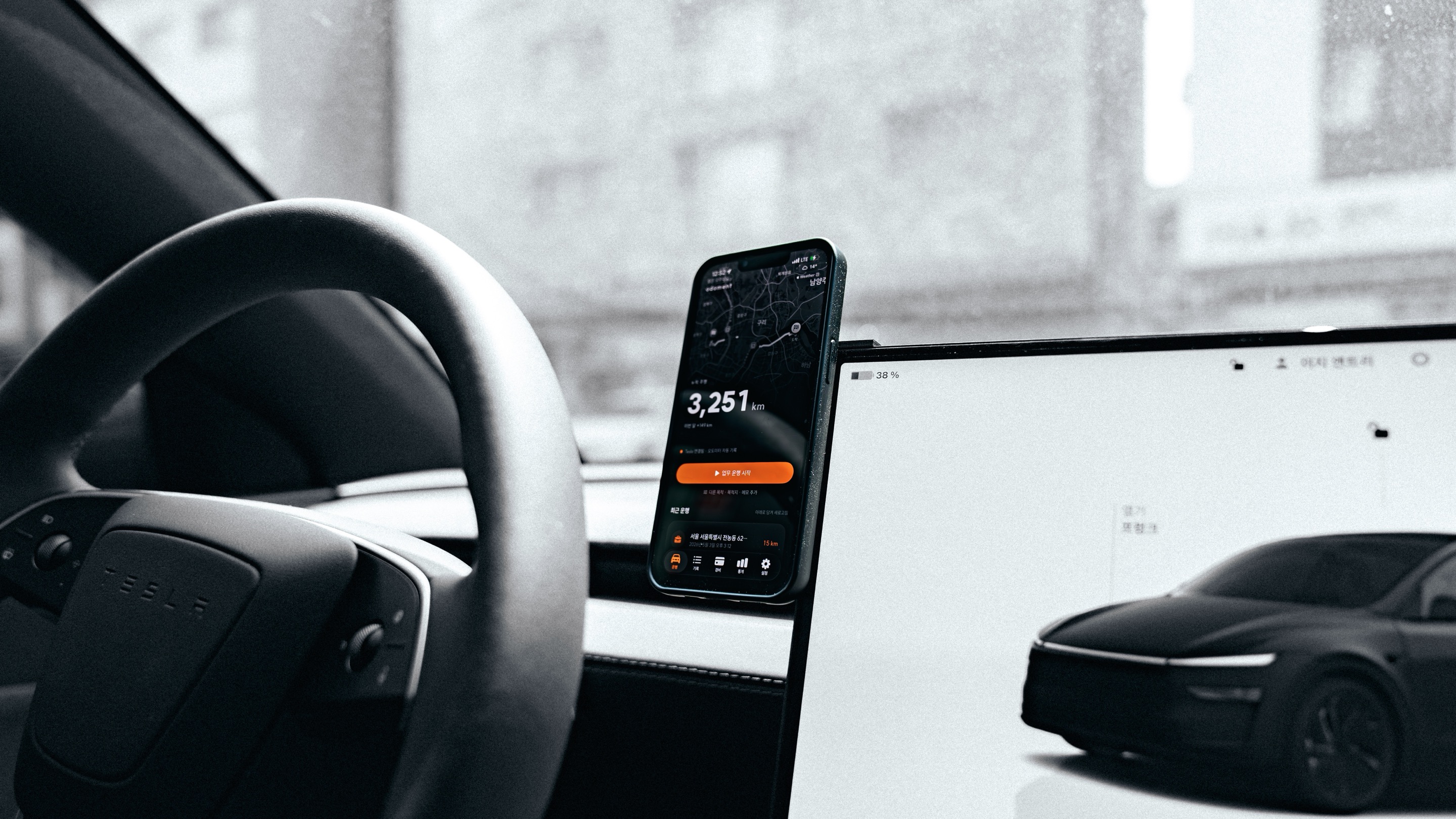 Tesla 운전석에 거치된 iPhone 에서 ODOMENT 앱이 자동으로 운행을 기록하는 모습